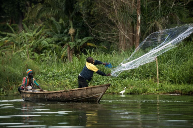 Throwing a fishing net by local men from a boat
