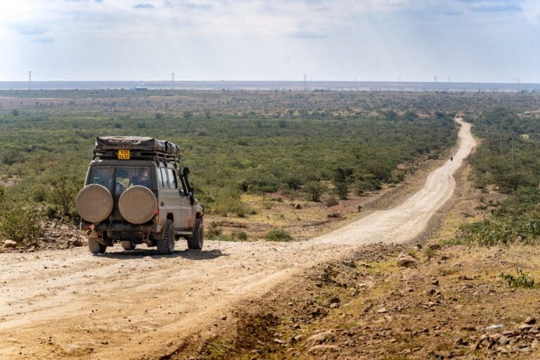 véhicule de safari sur une piste en terre dans la savane kenyane