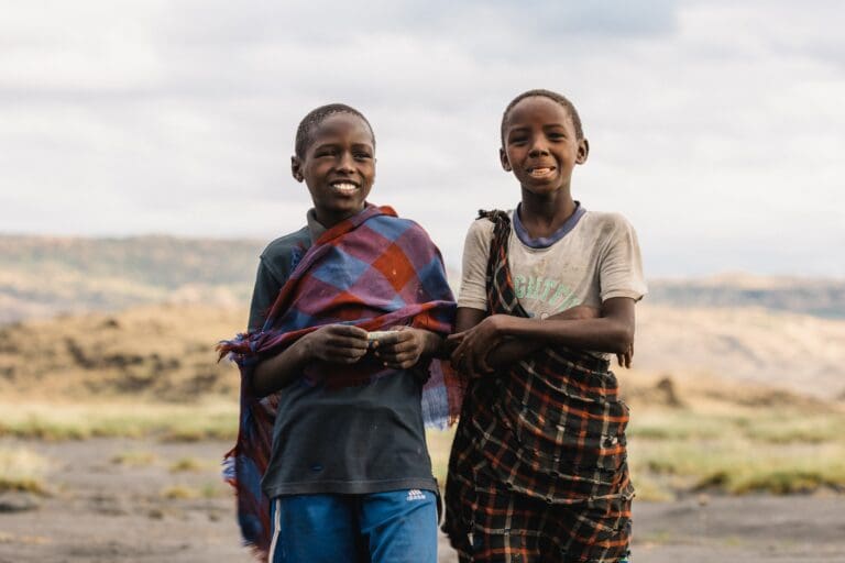 two young Tanzanian boys smiling in traditional clothing